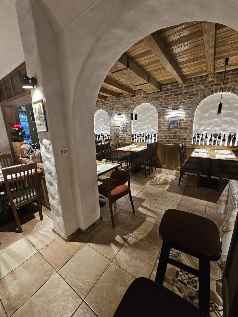 A white plastered arch opening onto the dining room with a wooden beamed ceiling
